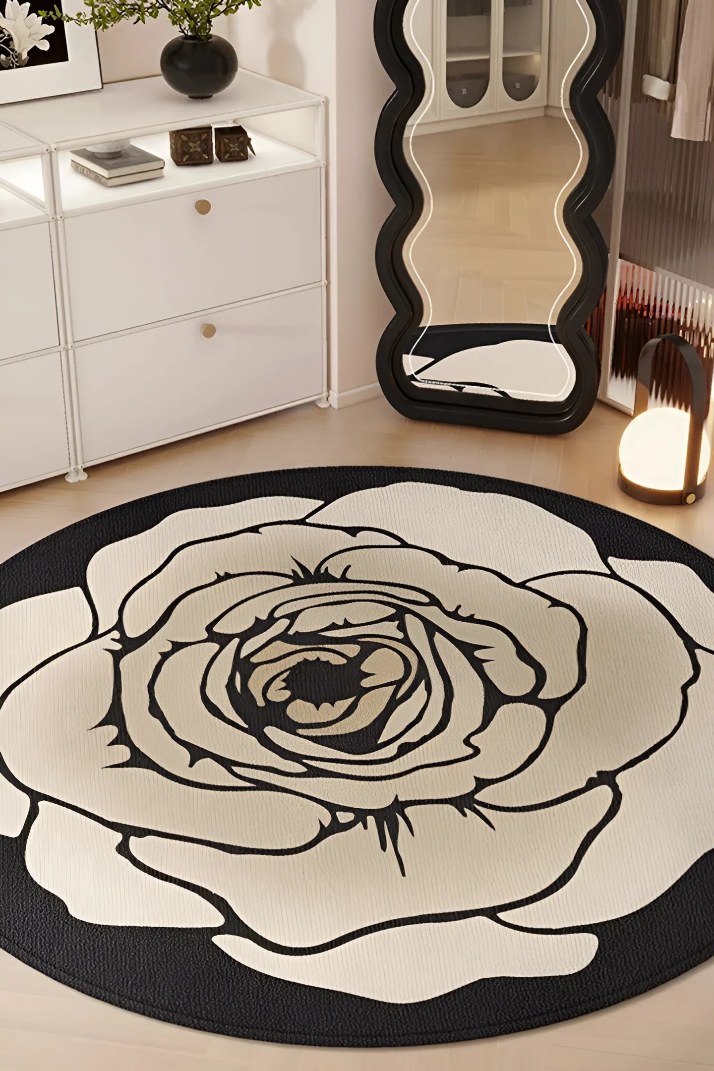 Tapis de sol rond bohème "Luna", design Rose Graphique noir et beige, près d'un miroir.