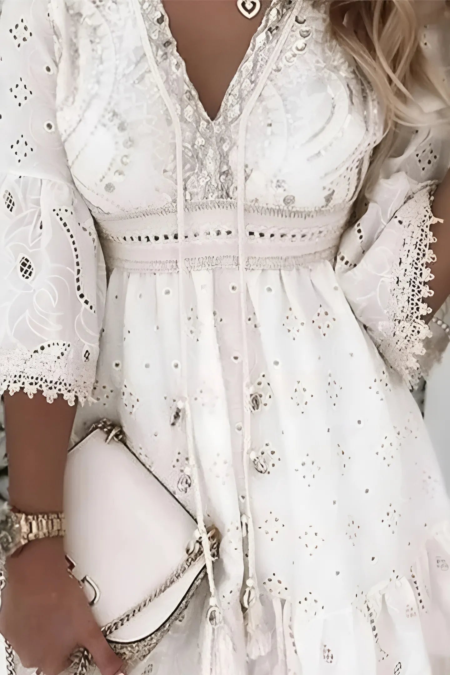 Texture de la broderie anglaise sur le buste d'une robe bohème chic de couleur écru.